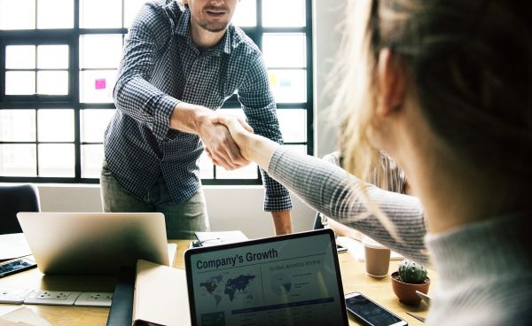 Man and woman shaking hands in a conference room